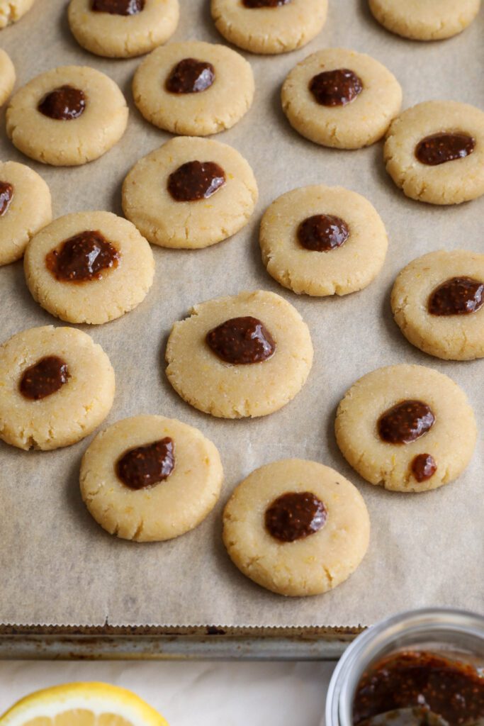 Lemon Almond Flour Thumbprint Cookies unbaked on parchment lined baking sheet