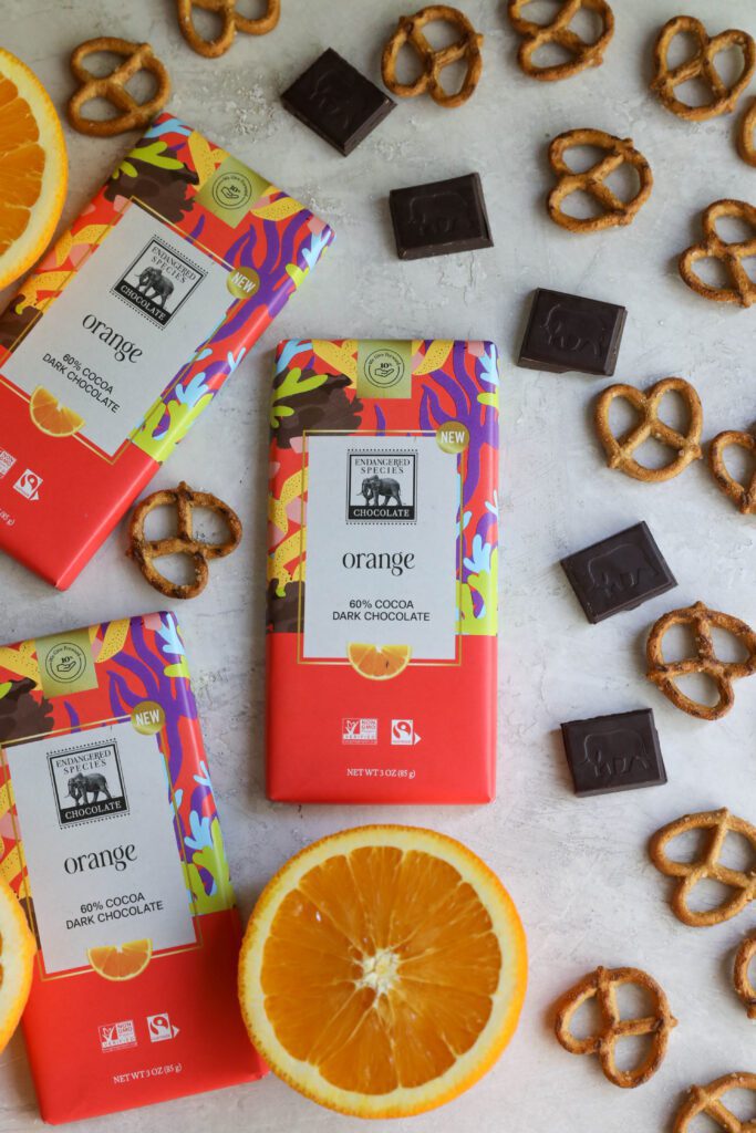 Endangered Species orange dark chocolate bars with orange halves, chopped chocolate squares, and pretzels by Flora & Vino
