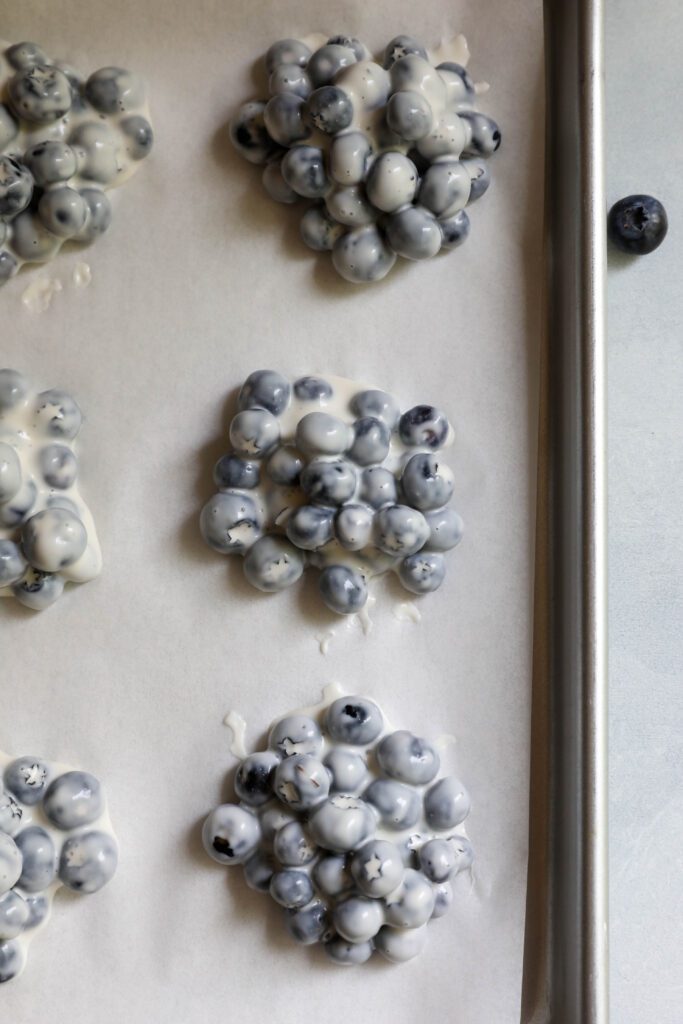 blueberry yogurt clusters on parchment lined baking sheet