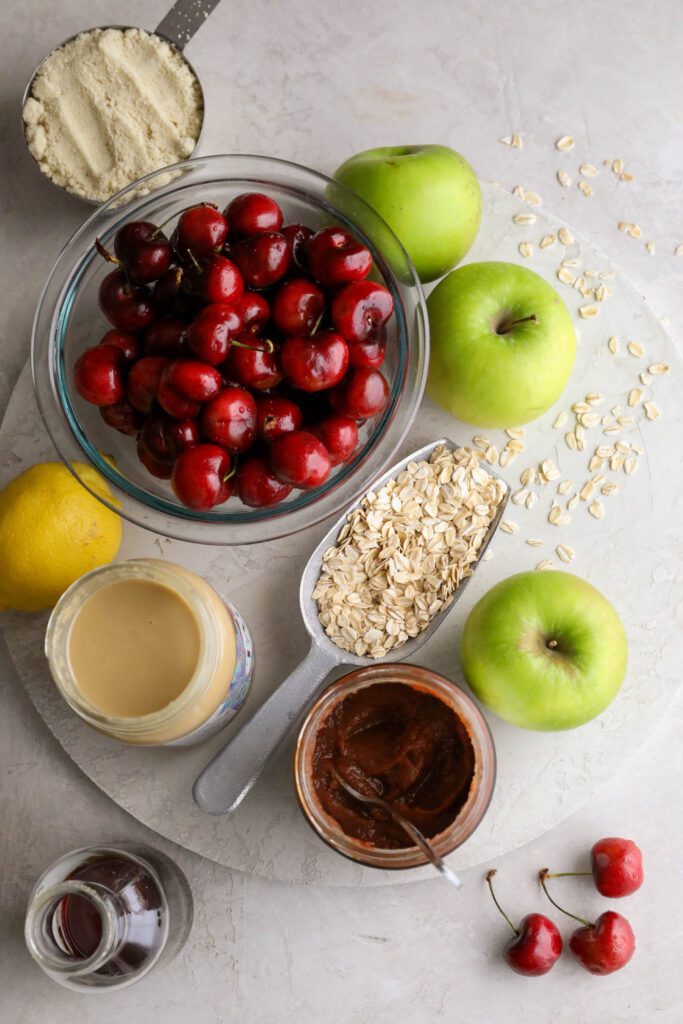 apples, cherries, oats, apple butter, tahini, maple syrup, lemon, and almond flour on board