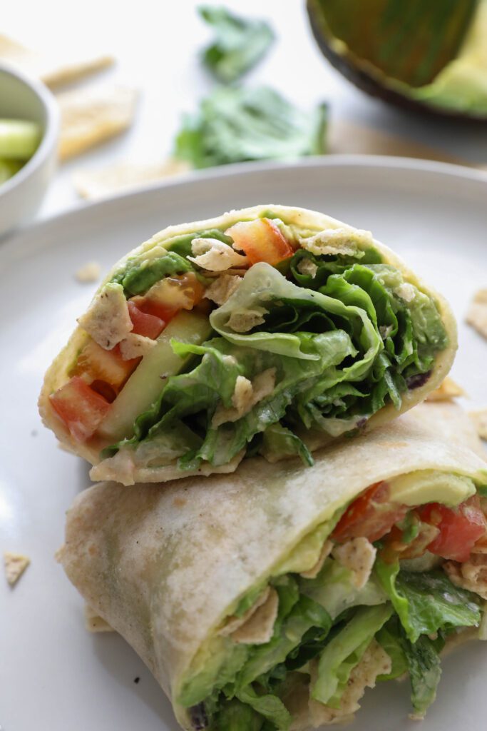 Salad Crunch Wrap sliced in half on plate by Flora & Vino