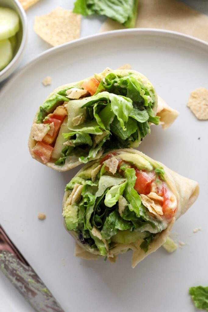 Salad Crunch Wrap sliced in half on plate by Flora & Vino