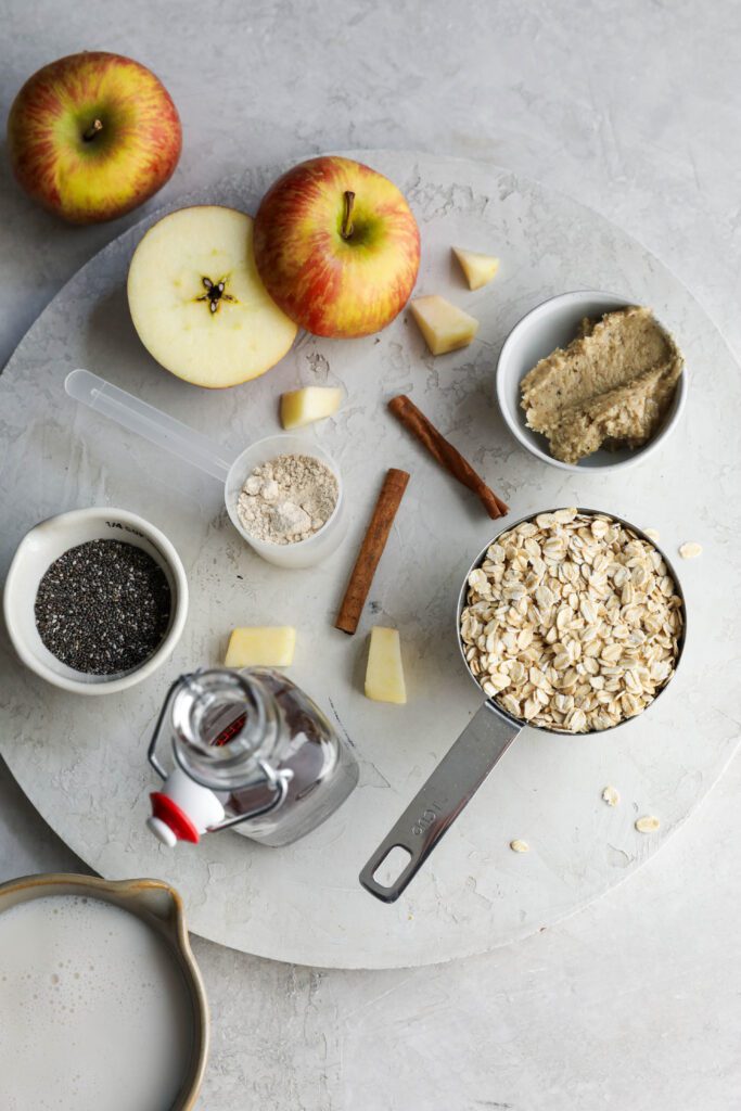 ingredients for apple pie overnight oats on circular board by Flora & Vino