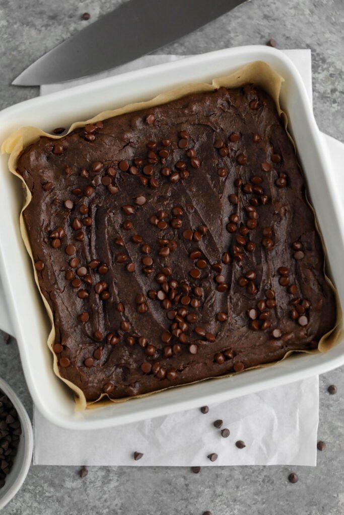 Flourless Vegan Brownies baked in parchment lined square pan by Flora & Vino 