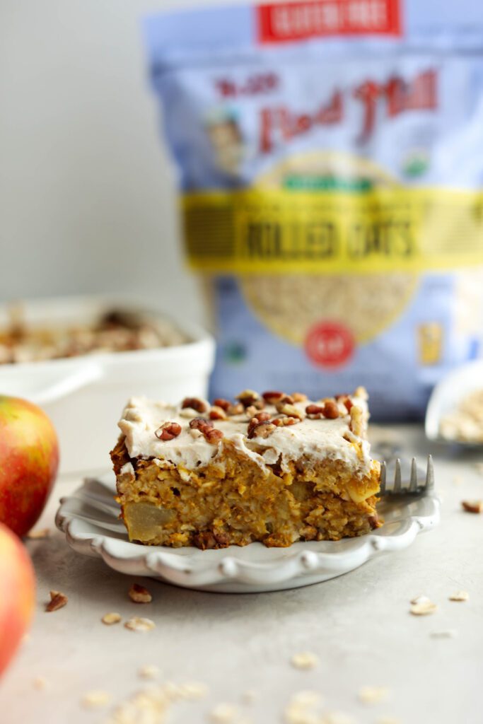 Pumpkin Apple Baked Oats slice with Bob's Red Mill oats in background by Flora & Vino