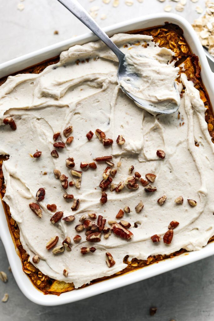 cream cheese frosting spread on pumpkin apple baked oats by Flora & Vino