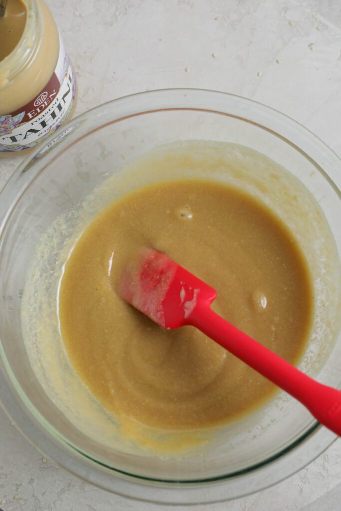 maple syrup and tahini mixed together on a glass bowl with spatula by Flora & Vino 
