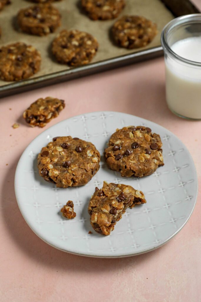Peanut Butter Chocolate Chip Oatmeal Cookies served on a plate with a glass of milk by Flora & Vino
