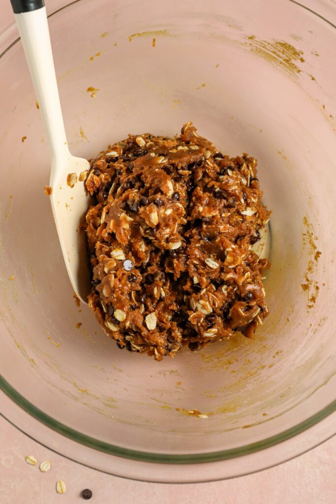 Peanut Butter Chocolate Chip Oatmeal Cookie Dough in bowl with spatula by Flora & Vino