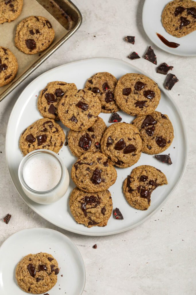 Vegan Chocolate Chunk Cookies served on plate with almond milk by Flora & Vino