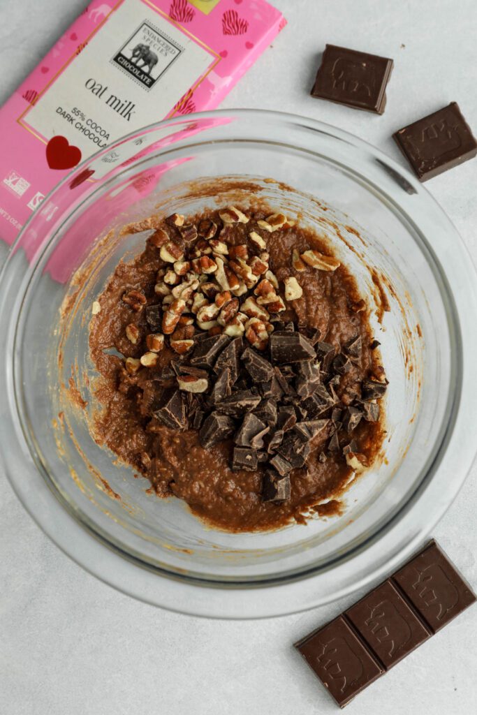 Single Serve Double Chocolate Chunk Cookie batter in mixing bowl with dark chocolate and chopped pecans mixed in by Flora & Vino