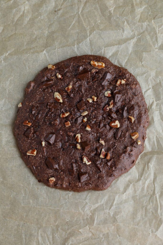 Single Serve Double Chocolate Chunk Cookie baked on parchment paper by Flora & Vino