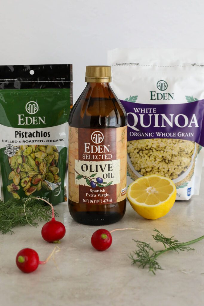 Eden Foods Pistachios, Eden Foods Olive Oil, Eden Foods White Quinoa standing with half a lemon, radishes, and fresh dill 