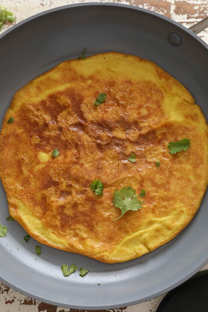 vegan omelette in pan topped with cilantro 