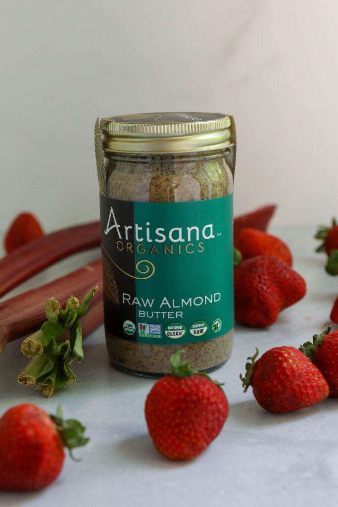Artisana Organics Raw Almond Butter with scattered strawberries and rhubarb 