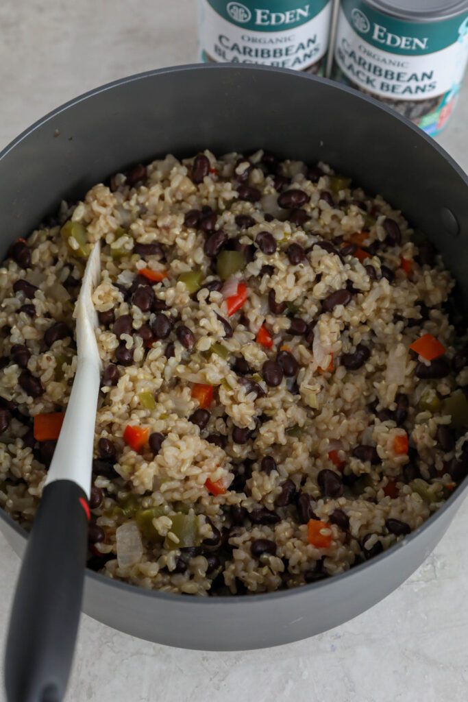 Caribbean Rice & Beans cooked in large pot with spatula 