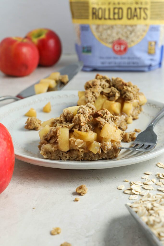 Apple Pie Crumble Bars on a plate with a fork with oats and apples on the side