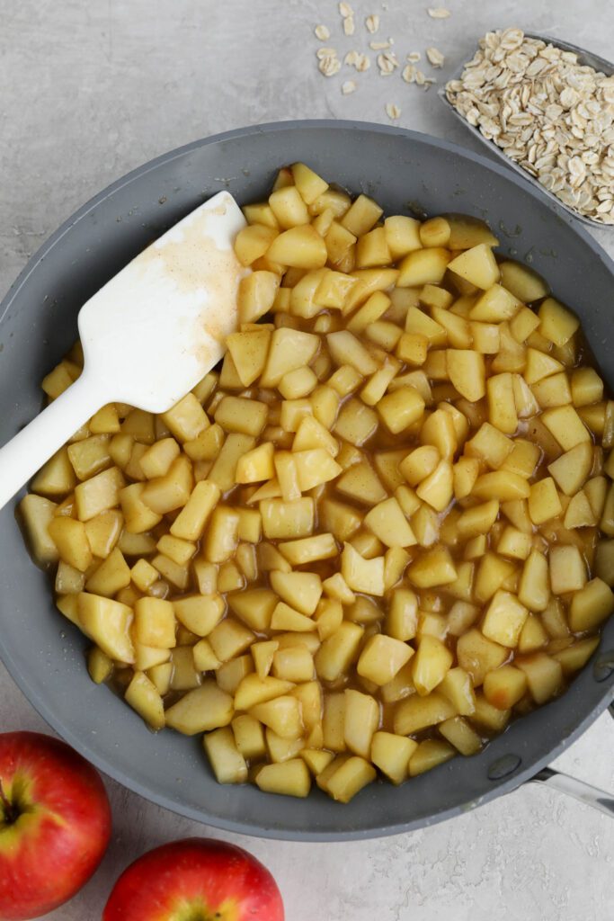 sautéed apples in pan with apples and oats on the side