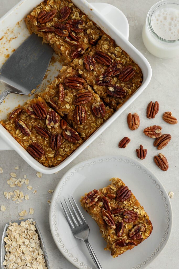 Sweet Potato Pie Baked Oatmeal served in casserole dish with pie server with pecans and oats 