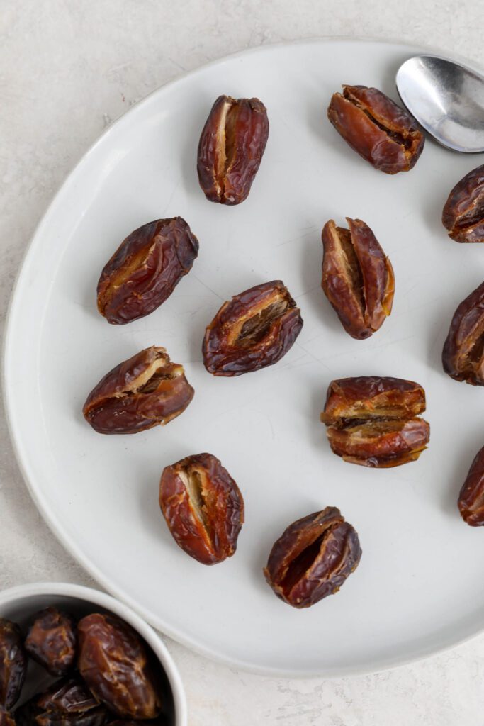 dates split in half on plate with pits removed