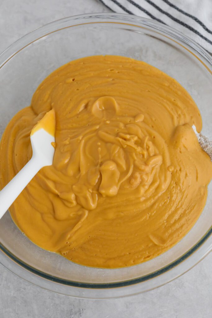 ingredients for sweet potato waffles in bowl with spatula