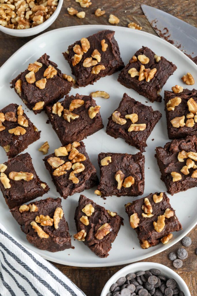 Red Bean Brownies served on white plate with chocolate chips and walnuts with blue and white striped towel