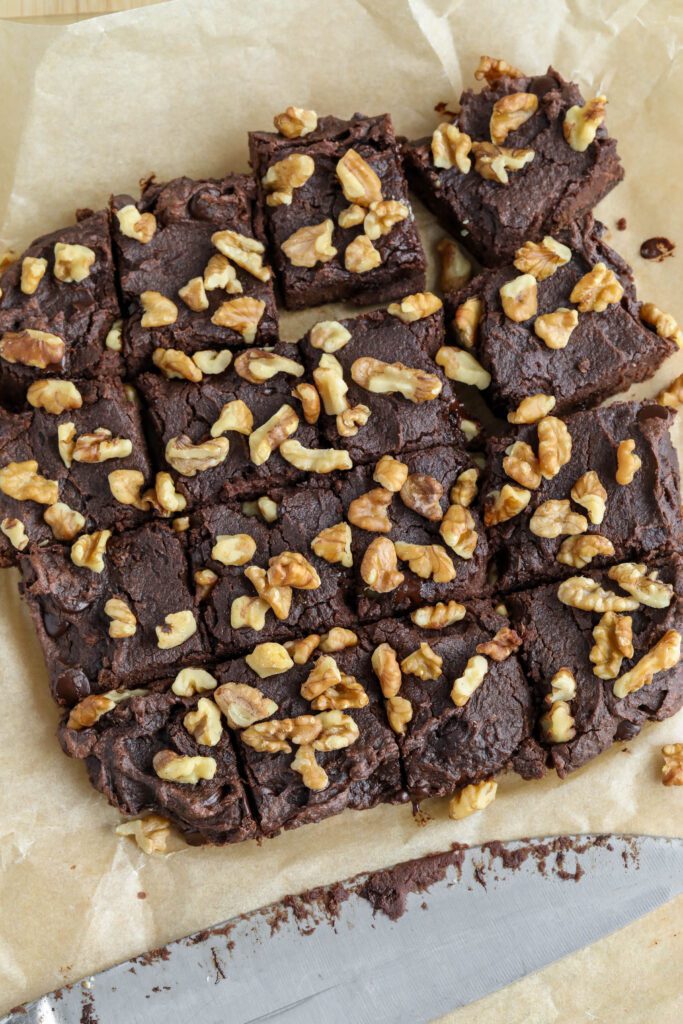 Red Bean Brownies on parchment paper cut into squares with knife