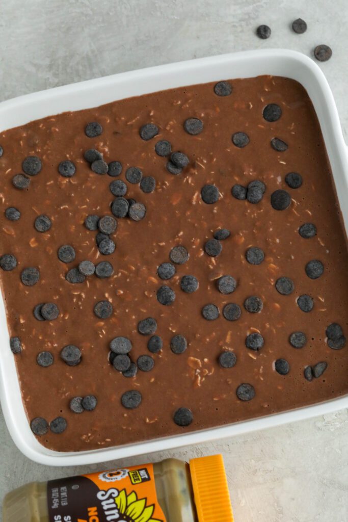 Red Velvet Baked Oatmeal batter in baking dish topped with dark chocolate chips 