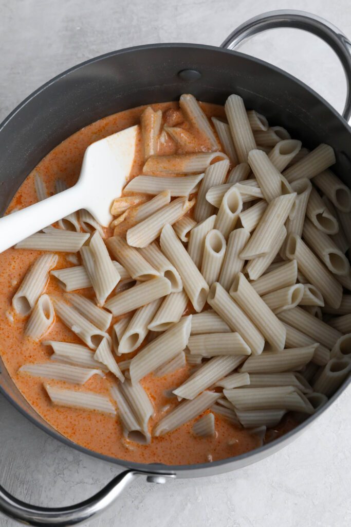 pasta in pink sauce in pot with spatula