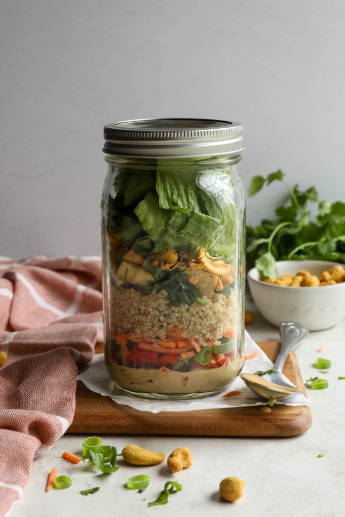 Thai Mason Jar Salads on board with cashews and cilantro in background 