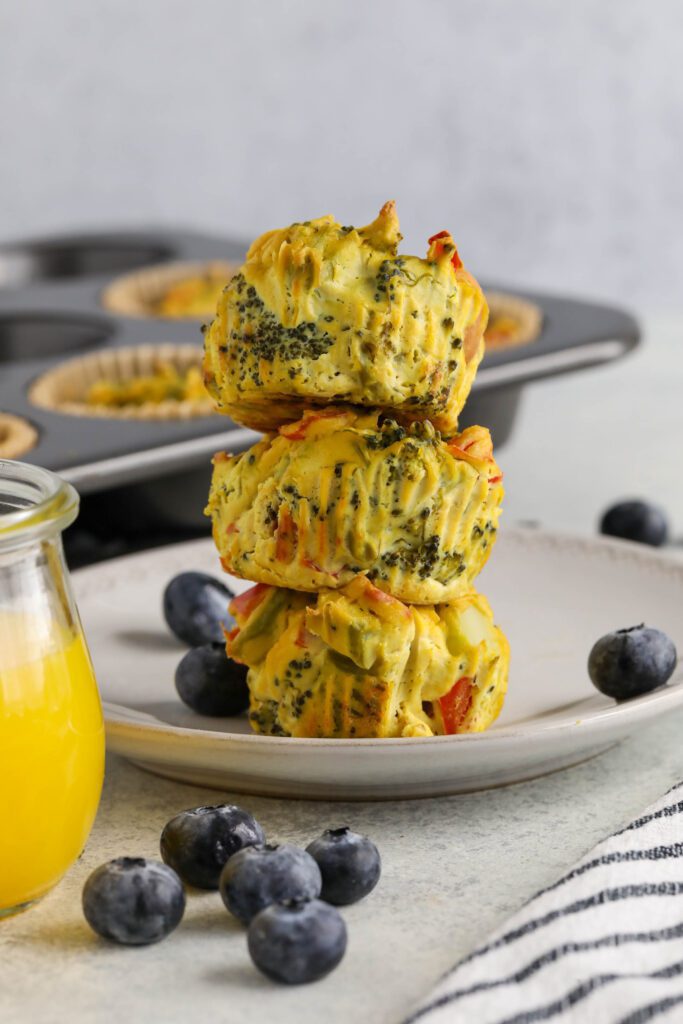 Tofu "Egg" Cups served on white plate with fork and blueberries with glass of orange juice