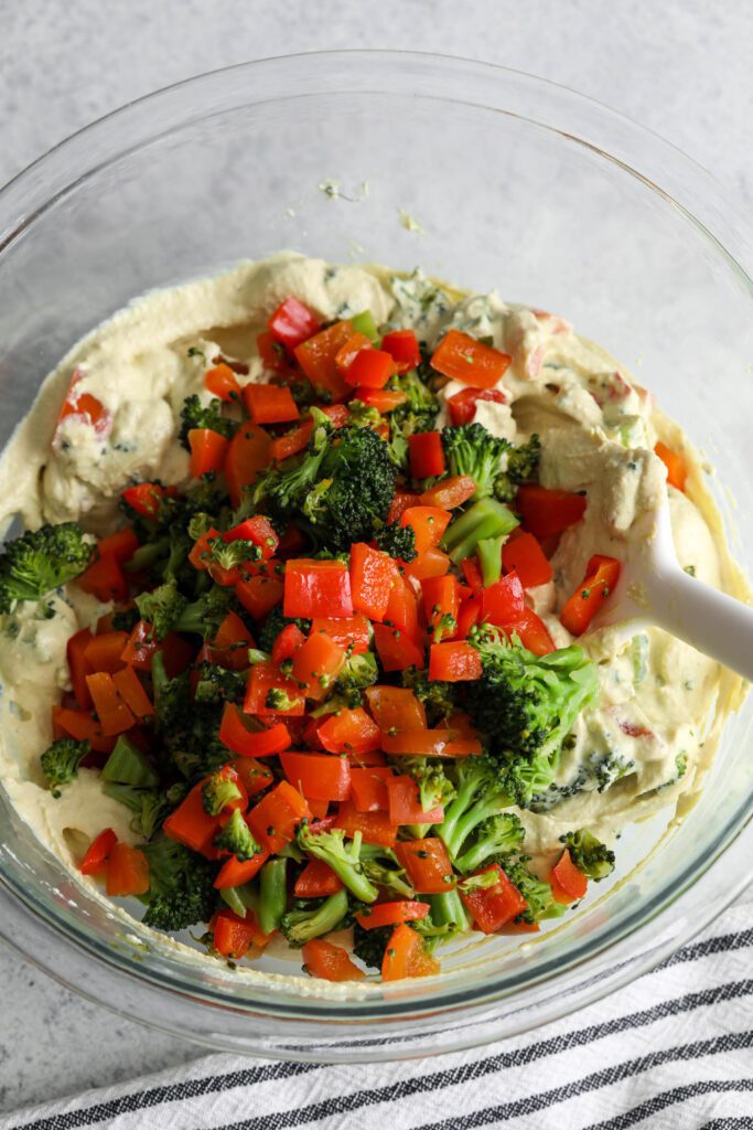 vegetables mixed in tofu batter in bowl with spatula 