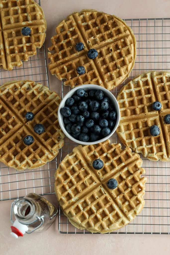 Vegan Applesauce Waffles on cooling rack topped with blueberries