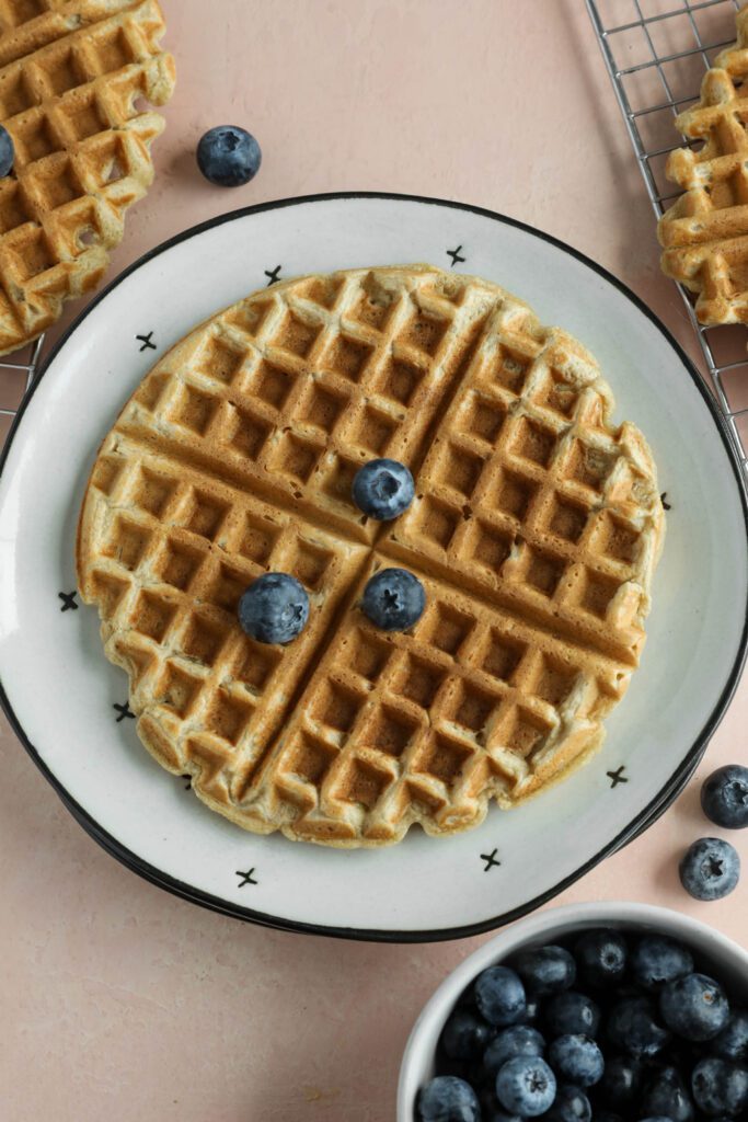 Vegan Applesauce Waffles served on plate topped with blueberries
