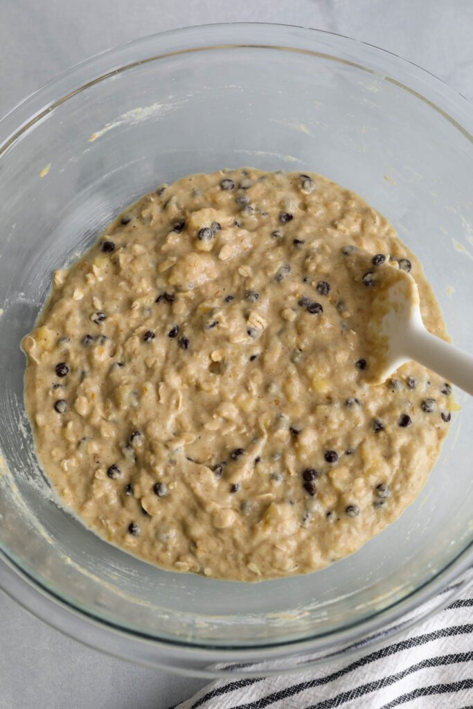 Banana Oatmeal Chocolate Chips Muffin batter mixed in bowl with spatula