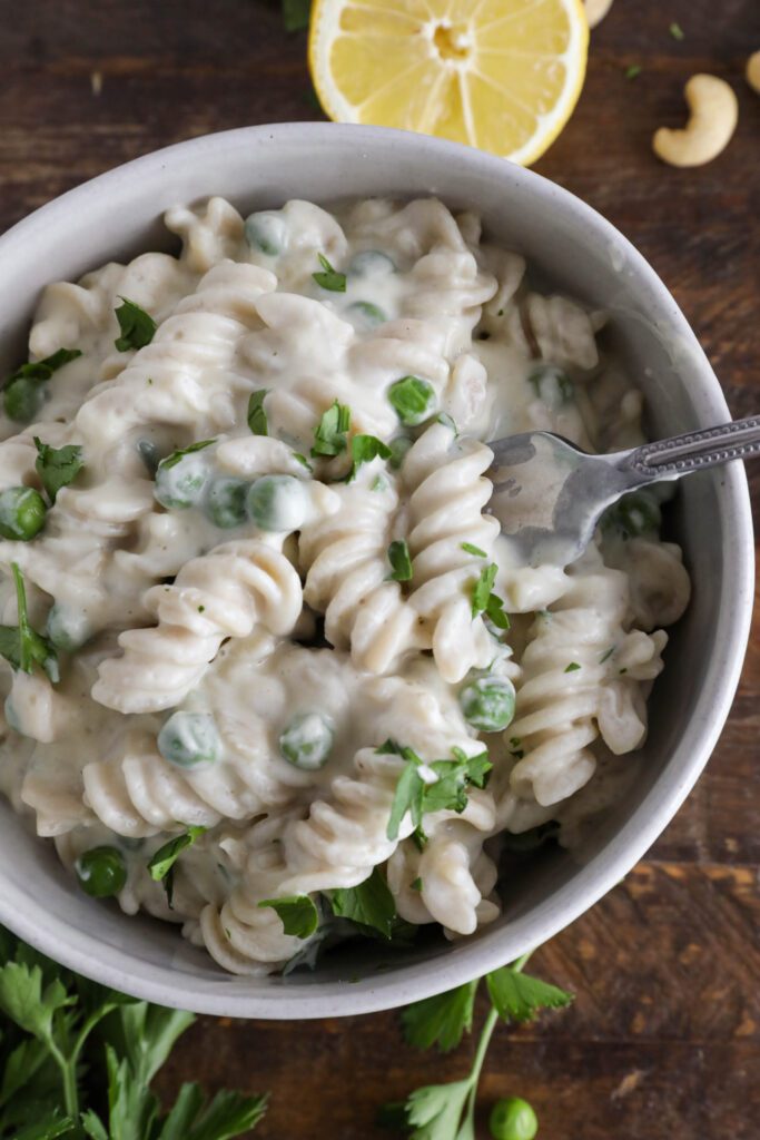 Cauliflower Cashew Alfredo served in bowl with fork topped with parsley
