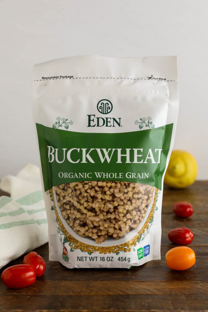Eden Foods Buckwheat in bag on wooden board with lemon and cherry tomatoes