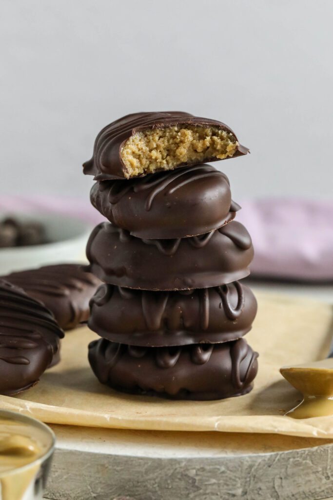 SunButter Chocolate Easter Eggs stacked on parchment paper with spoon of SunButter
