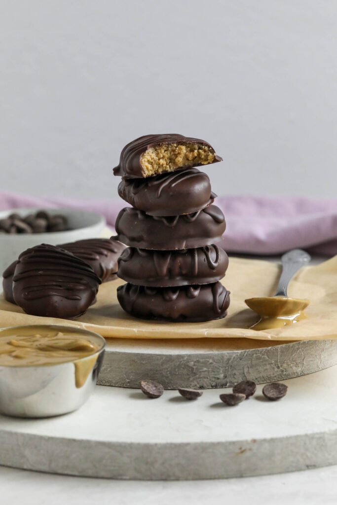 SunButter Chocolate Easter Eggs stacked on parchment paper with spoon of SunButter 
