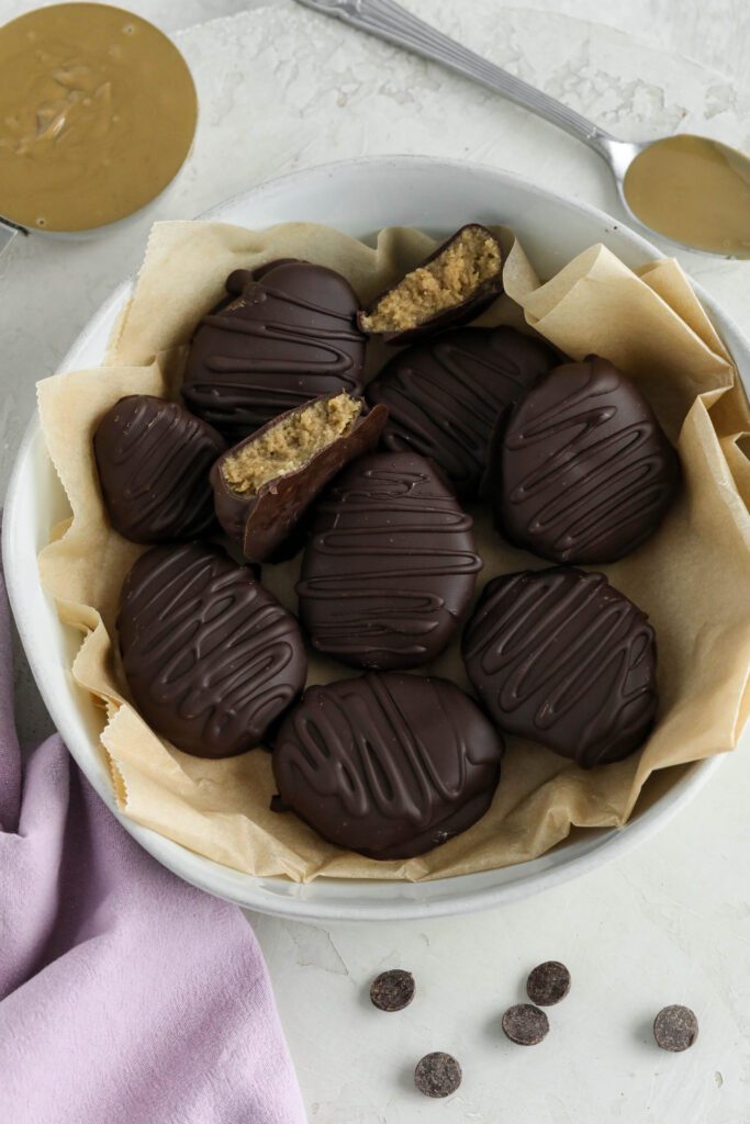 SunButter Chocolate Easter Eggs served in white bowl with parchment paper with SunButter and chocolate chips on the side