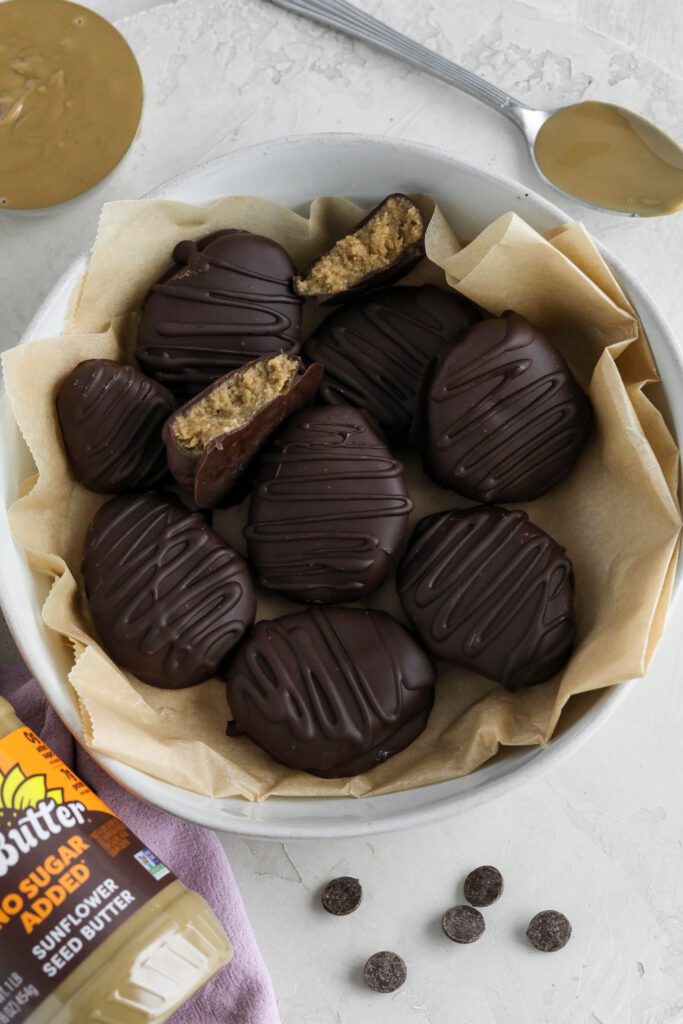 SunButter Chocolate Easter Eggs served in white bowl with parchment paper with SunButter and chocolate chips on the side