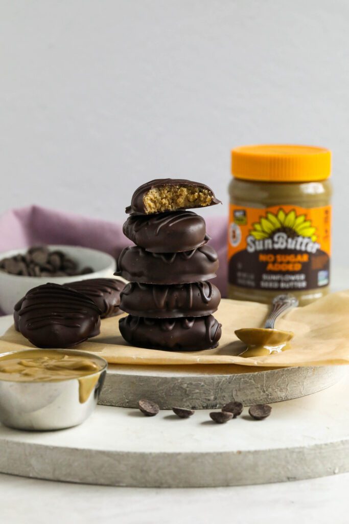 SunButter Chocolate Easter Eggs stacked on parchment paper with spoon of SunButter