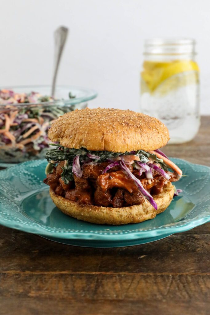 BBQ Lion's Mane Mushroom Sandwich served on blue plate with tahini slaw