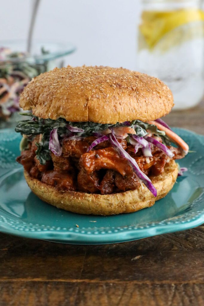 BBQ Lion's Mane Mushroom Sandwich served on blue plate with tahini slaw