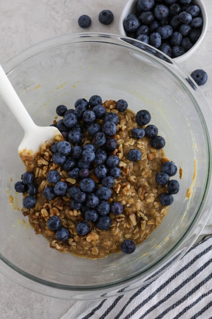 Blueberry SunButter Breakfast Cookies with blueberries mixed on top with spatula 