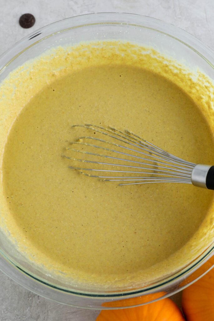 pumpkin turmeric waffle batter in bowl with whisker