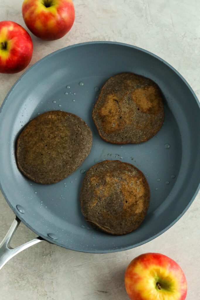 vegan apple buckwheat pancakes cooked in pan