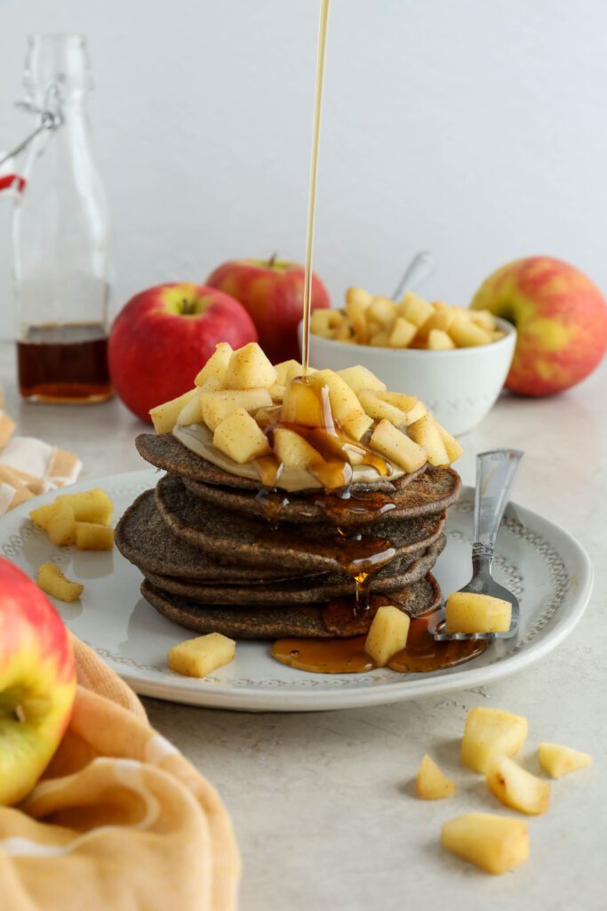 Vegan Apple Pie Pancakes served on plate topped with apple compote and maple syrup