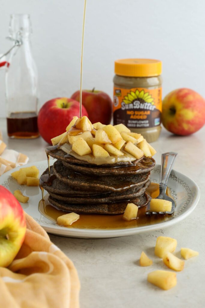 Vegan Apple Pie Pancakes served on plate topped with apple compote and maple syrup
