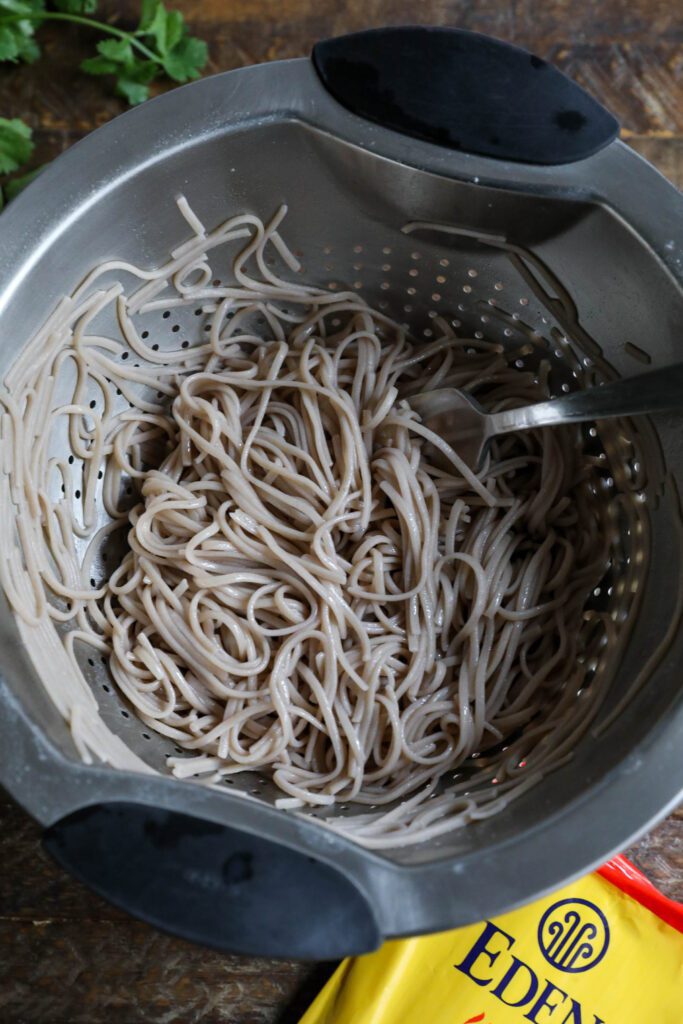 Buckwheat soba noodles in colander with fork